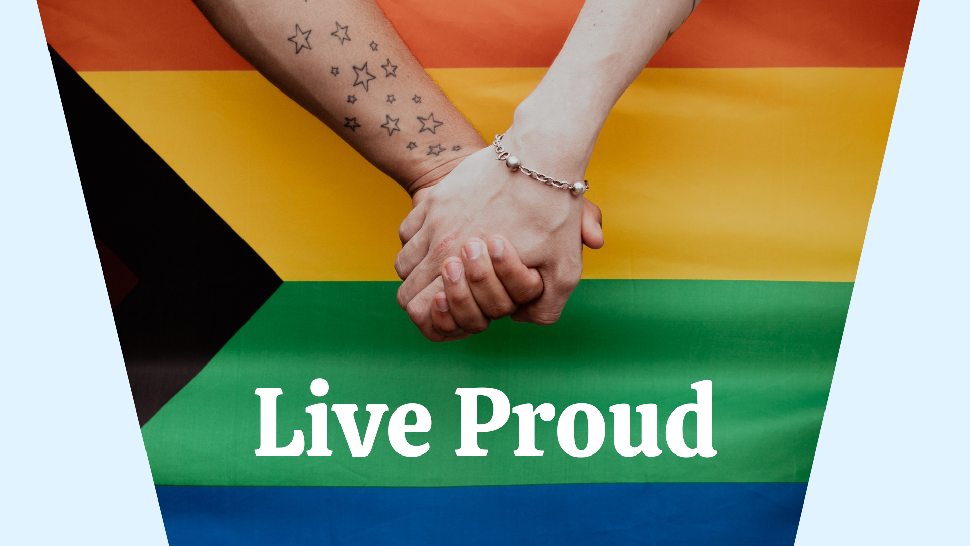 Close up of two hands holding in front of a pride flag. The text "Live Proud" is below the hands.