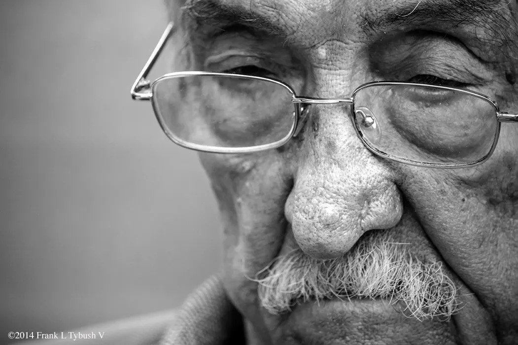 A black and white photo of an extreme close up of an older man.