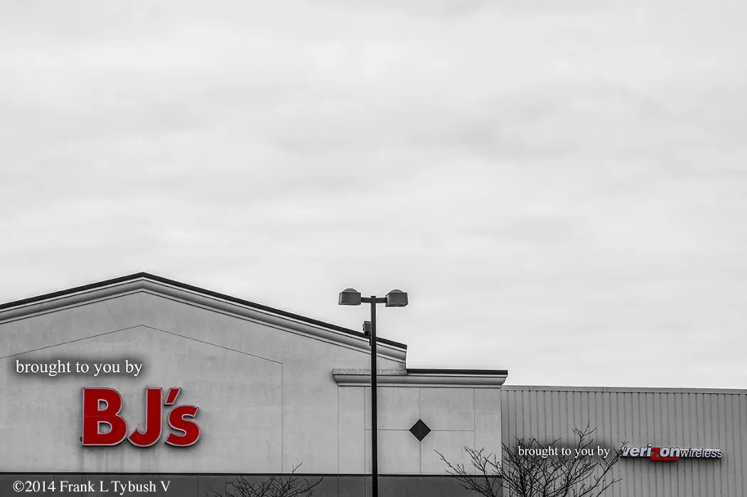 A black and white photo of BJ's wholesale club. The logo is flanked by text saying, "brought to you by," and the logo is in color.